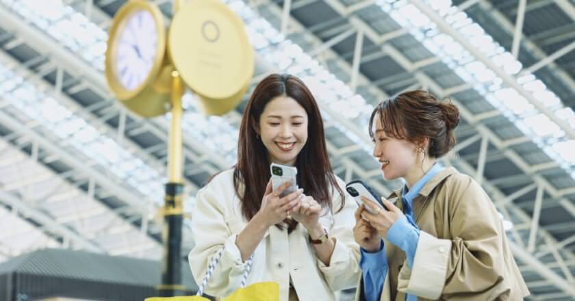 大阪 アーバンリサーチのふたりがOSAKA STATION CITYで乗り換え時間を検索している様子の写真
