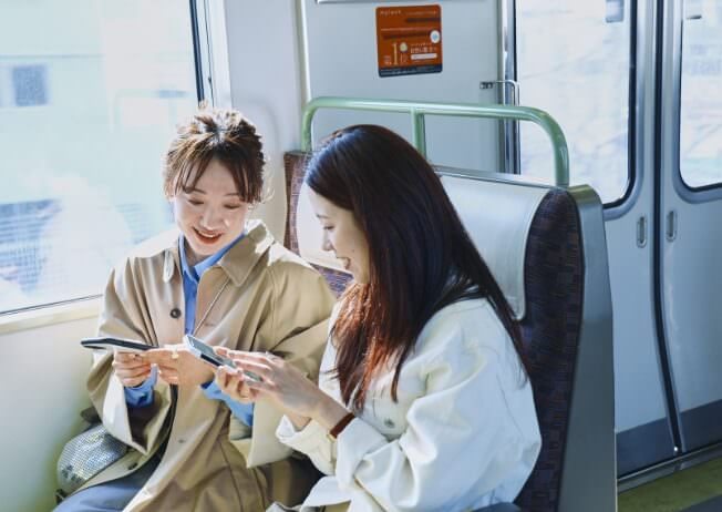 アーバンリサーチのふたりがJR神戸線に乗車中の様子の写真