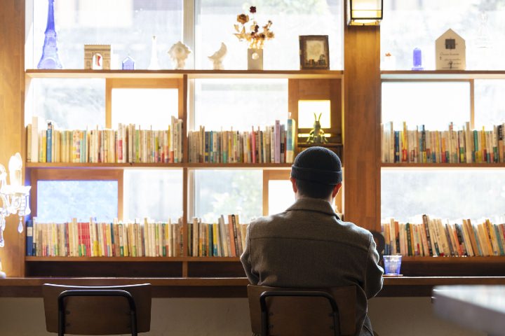 maco maretsさんが月明かりの書斎で本を読む様子