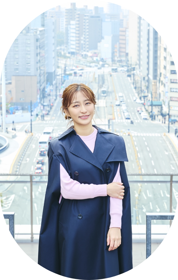 広島駅前の街並みを背景に、まちの広がりを感じながら立つ枡田絵理奈さん